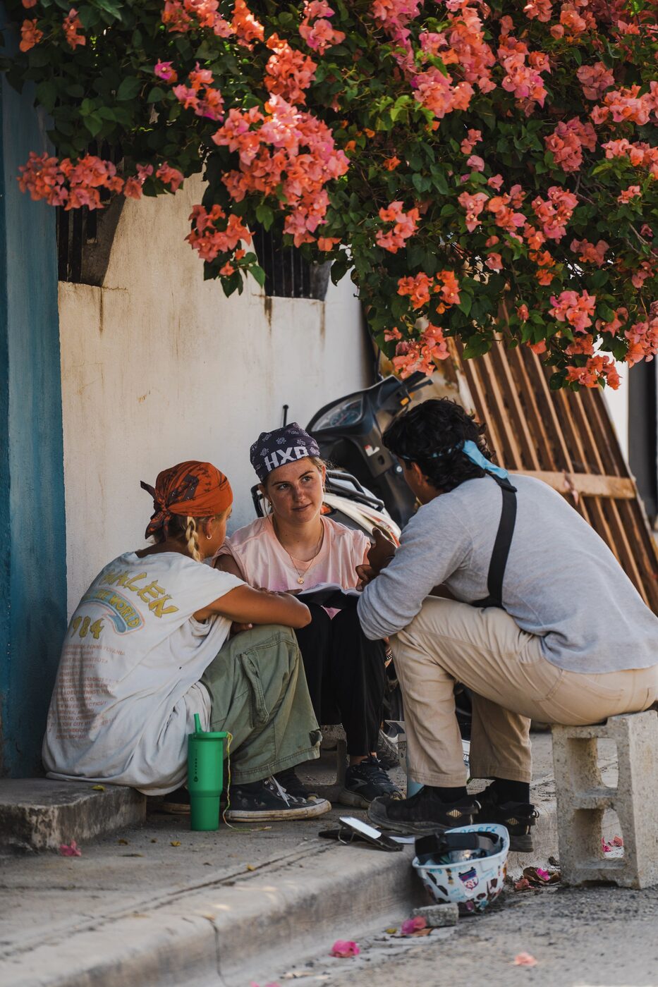 A Trip Leader talking with Builders under the bougainvillea